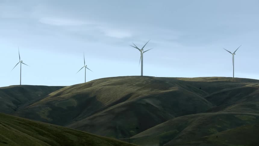 Five large power generating wind mills rotate in rural America creating vast amounts of green and renewable energy
