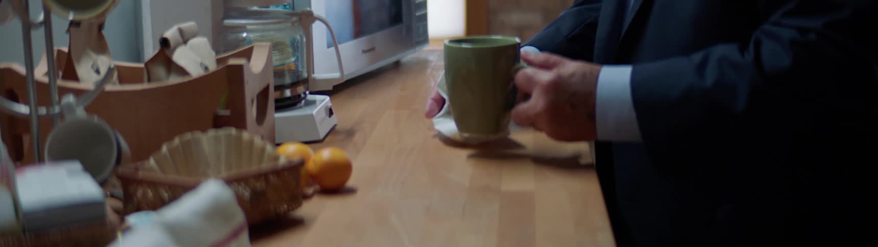 A man wipes the table and his mug