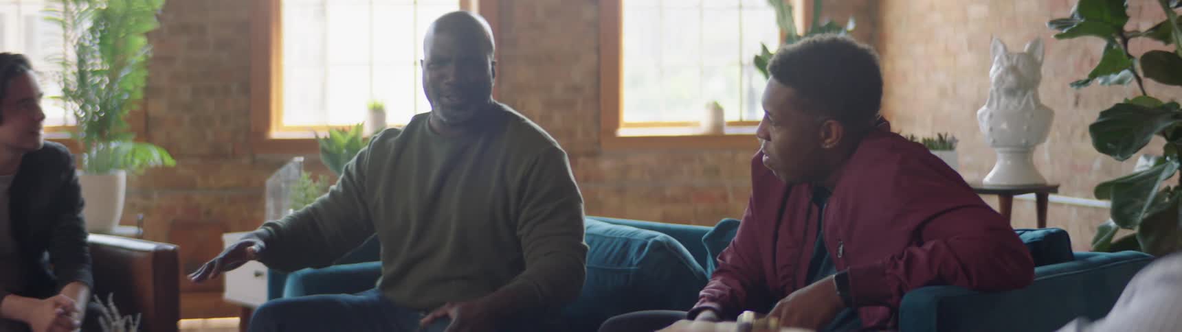 Four friends sit inside a house and talk