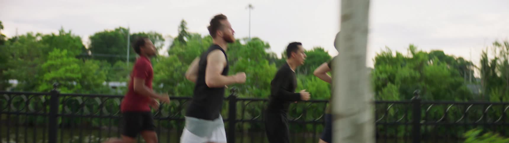 Four men running along a path