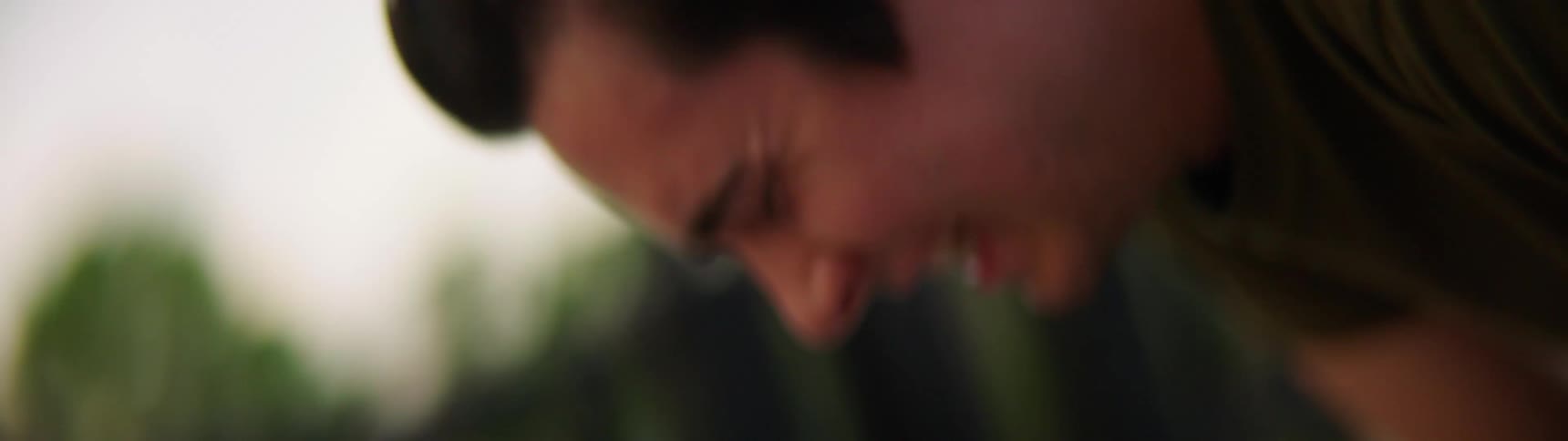 A man bends over to scowl in distress before rising again to run his hand through his hair
