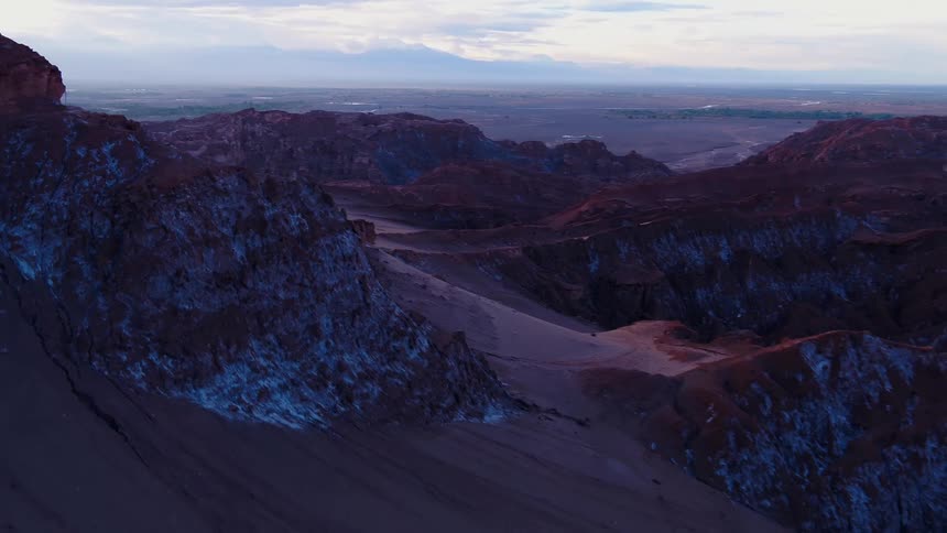 Sand dunes form alongside rocks in a canyon