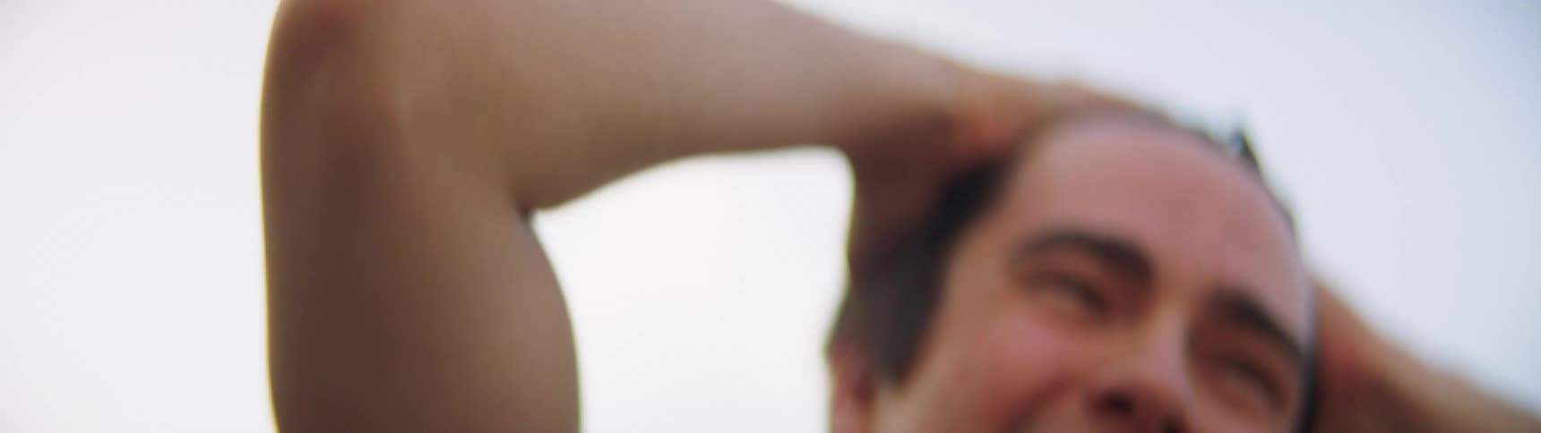 A white male exercises with some stretching outdoors