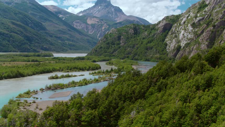 A river with trees with mountains and the sky in the background