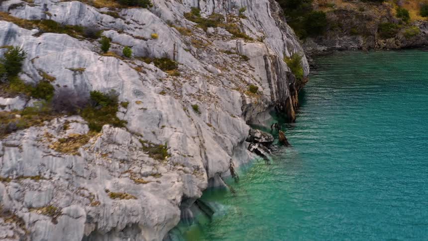 The water along the shoreline as it meets a cliff