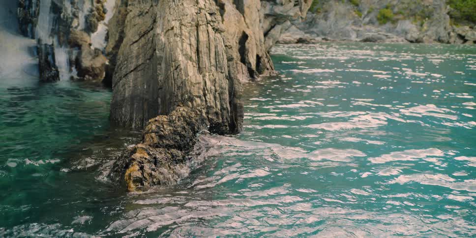 Large rocks sit in the blue water of the lake