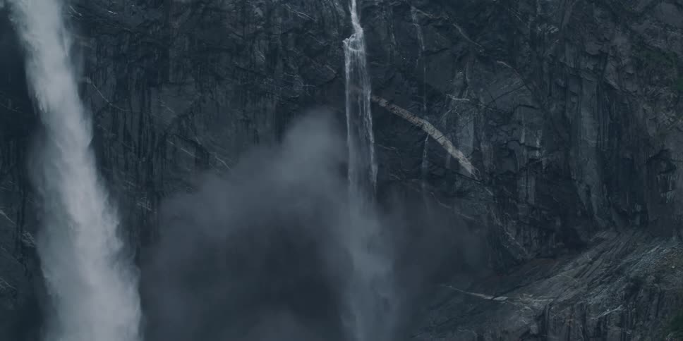 Snow flows down a cliff from a hanging glacier