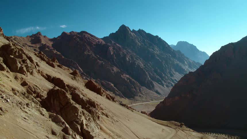 A road runs across the side of a mountain and through a valley