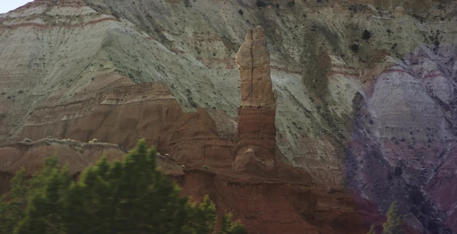 A rock formation on a mountain rises into the air