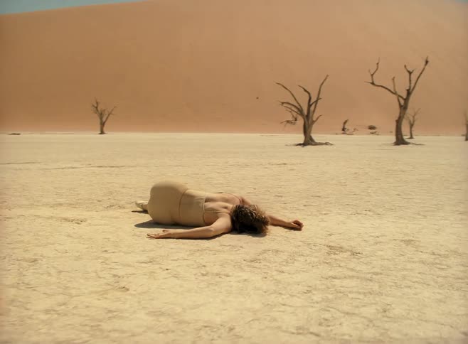 A teenager lies in the desert