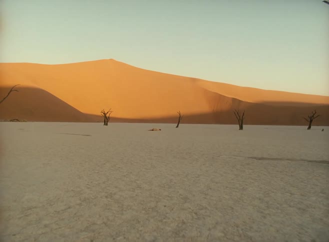 A white woman lies in the middle of a desert