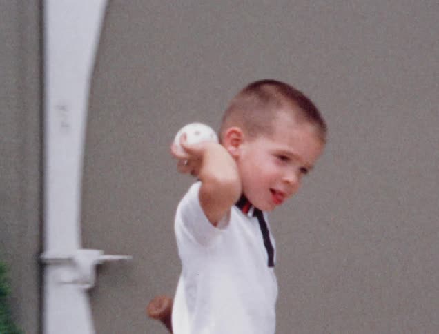 A little boy throws a baseball
