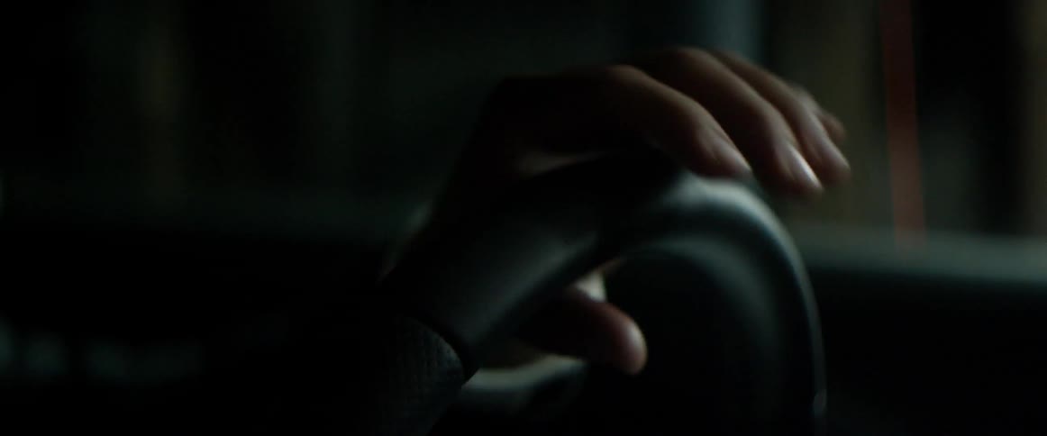 A hand gripping a steering wheel
