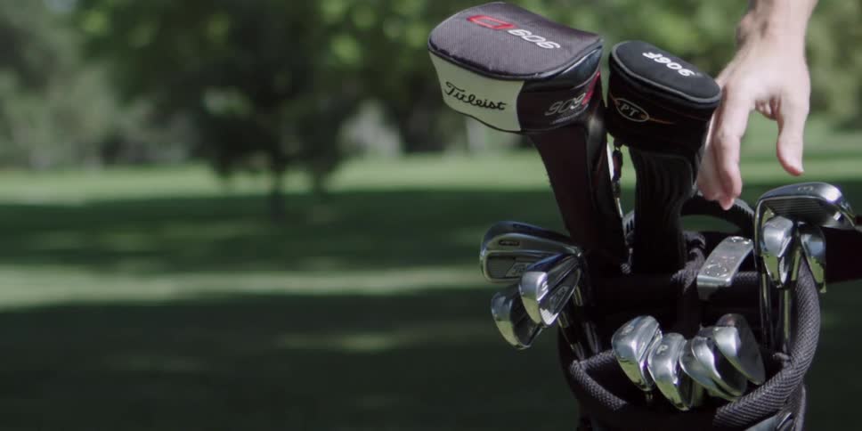 A man takes a golf club out of a bag