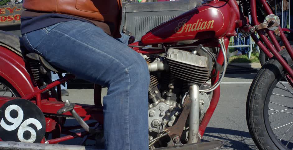 A man sits on his motorcycle outside
