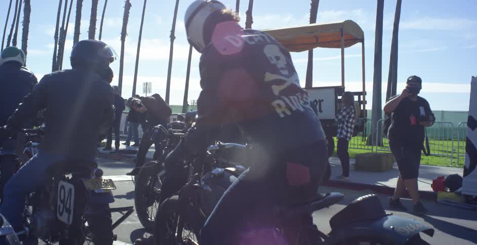 A man gets on his motorcycle