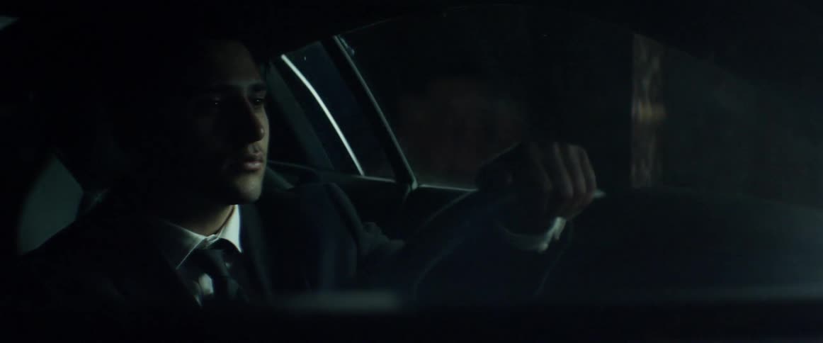 A man sits in the driver's side of a car