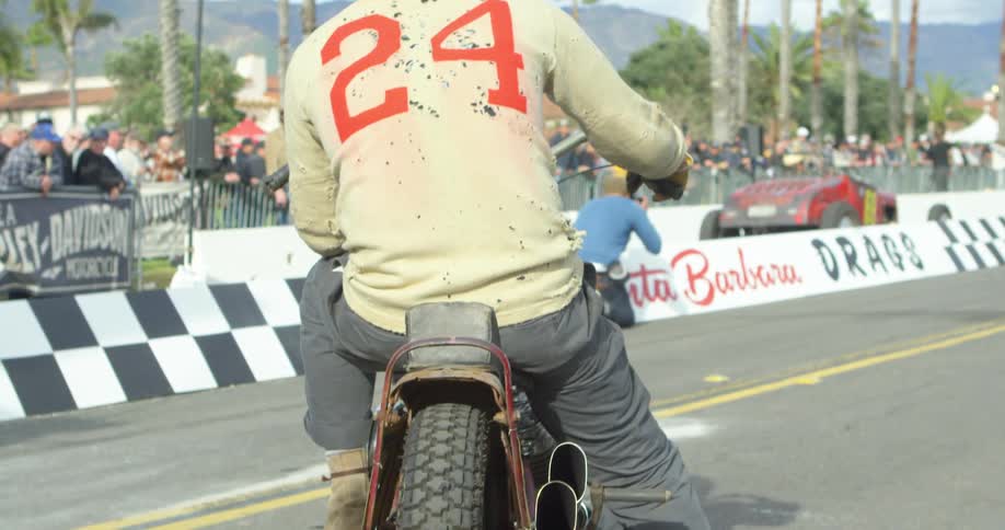 Man wearing a helmet sits on a motorcycle on a racetrack
