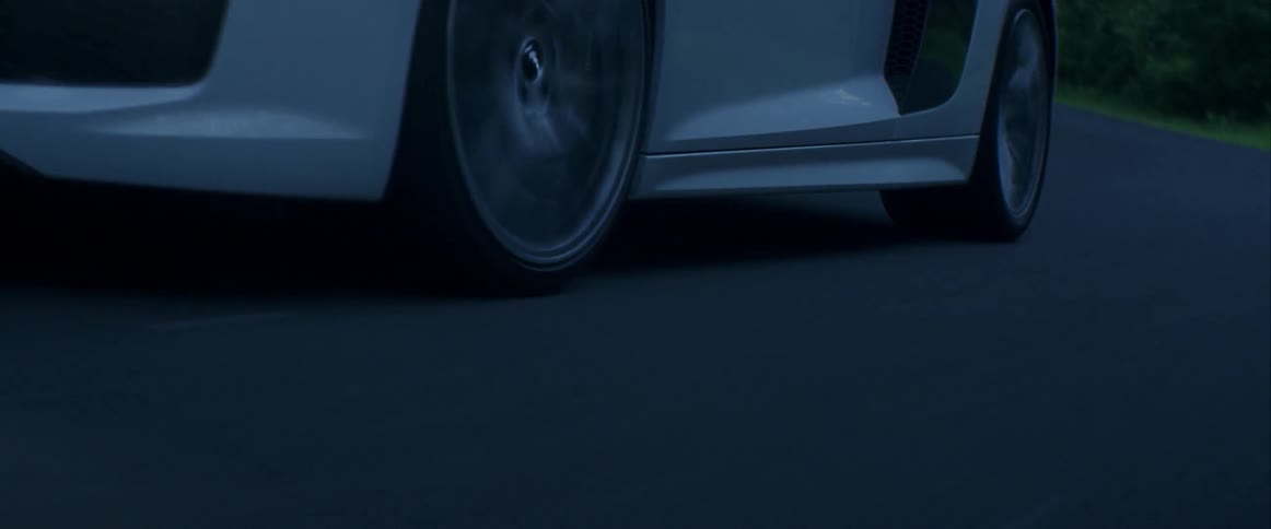 A white sports car turning a corner
