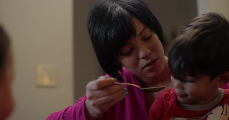 A son refuses to accept a spoonful of food from his mother