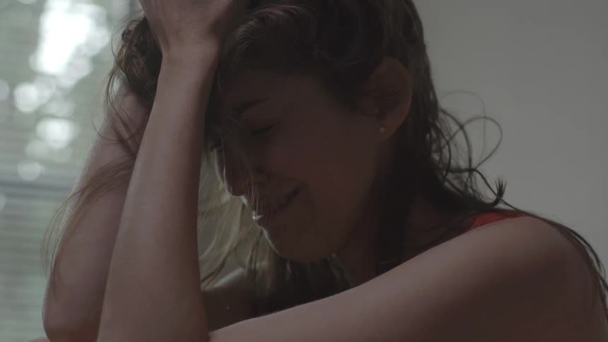A woman who is crying pulls her hands through her hair