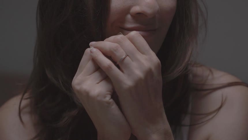 A woman plays with her hair and smiles