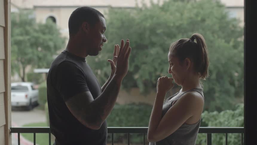 A woman punching the palms of a man's hands