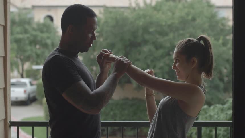 A man playfully teaching a woman how to throw punches