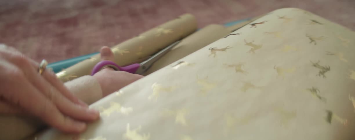 Scissors cutting a roll of wrapping paper