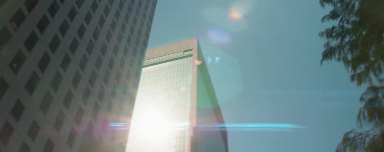 Sunlight reflecting off the windows of a tall building in a city
