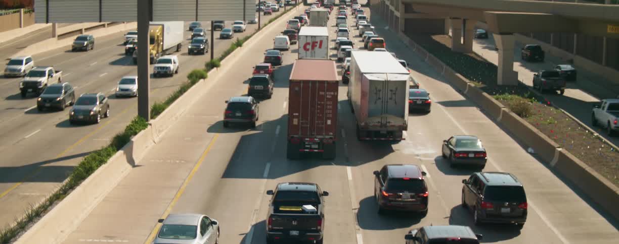 Cars are driving on a highway near a downtown city
