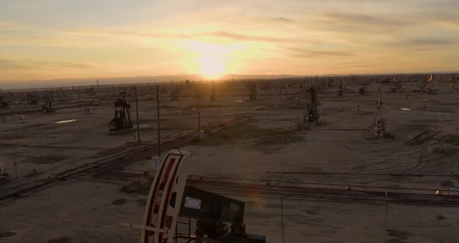 Pumpjacks pump out crude oil in the field at sunset