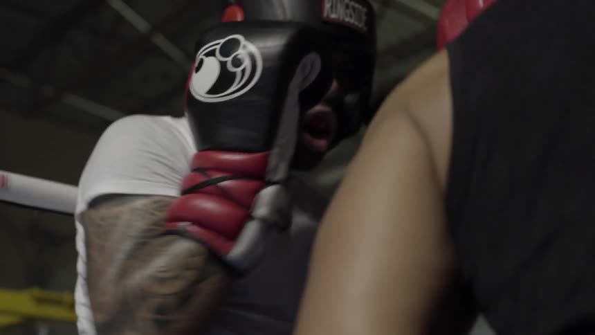 Two boxers train in a ring wearing amateur gear