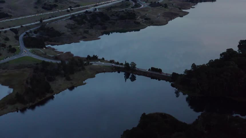 A bridge over a river with vehicles driving on it