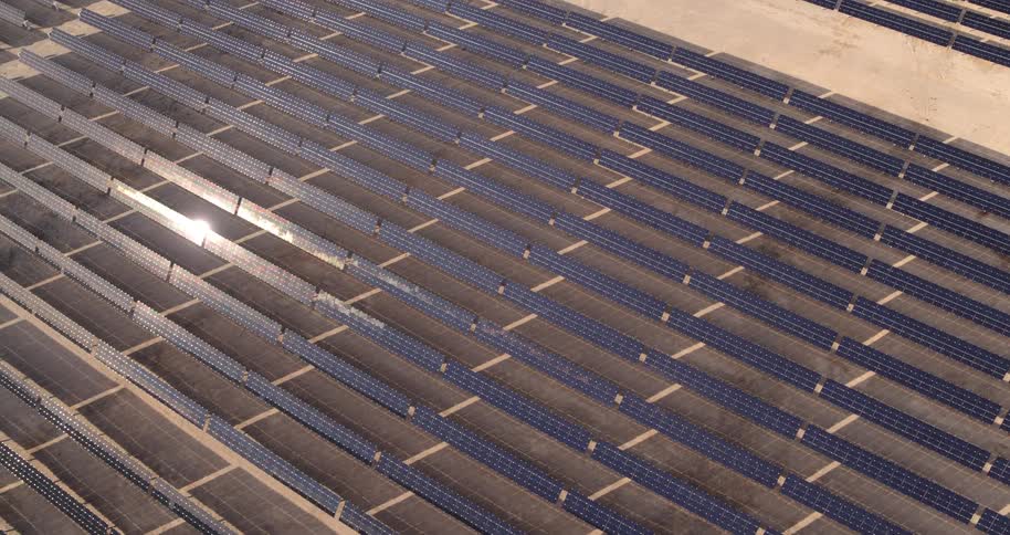 Sunlight reflects off rows of solar panels