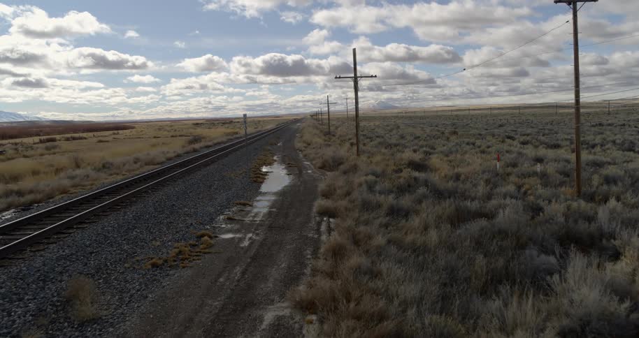 Train tracks next to a field