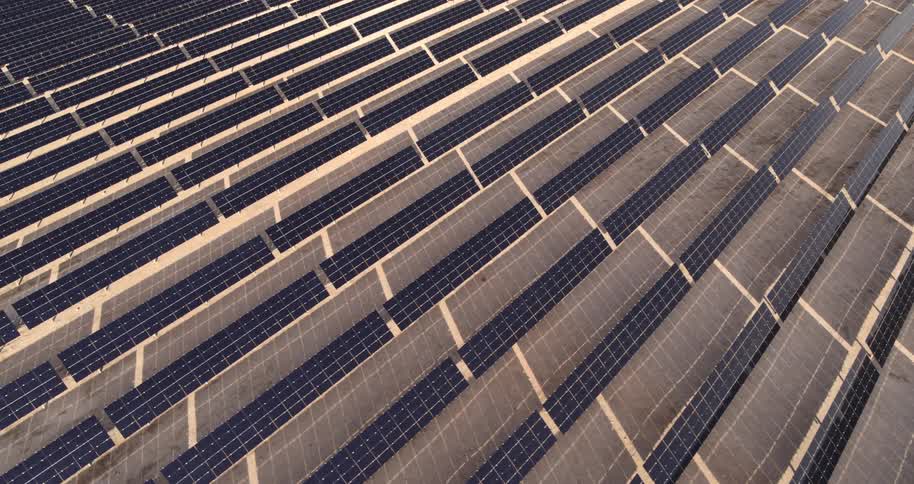 An aerial view of a solar energy farm with its large array of solar panels