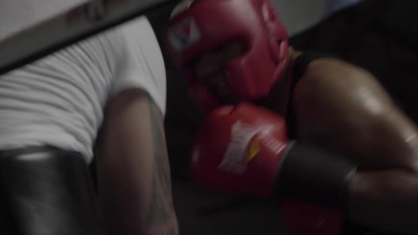 Two boxers train in a ring wearing amateur gear