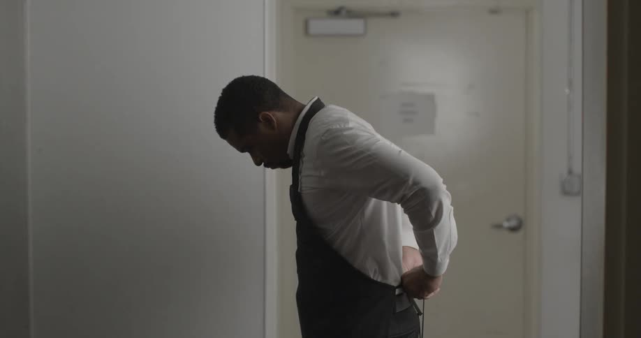 A man putting on an apron