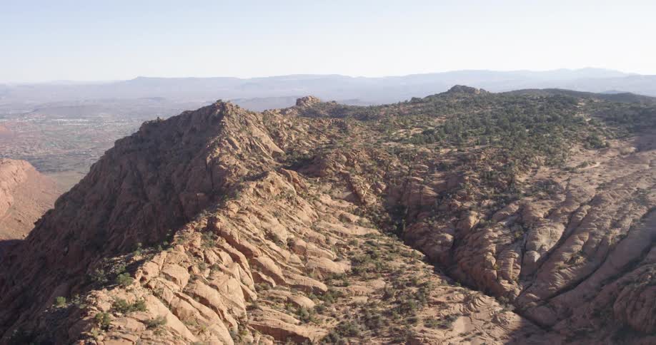 Mountains with vegetation on them sit under a blue sky