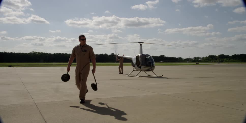 A man is walking away from a helicopter
