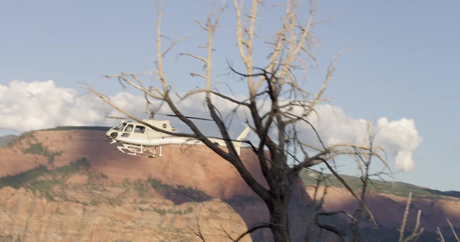 A helicopter flies near a mountain range