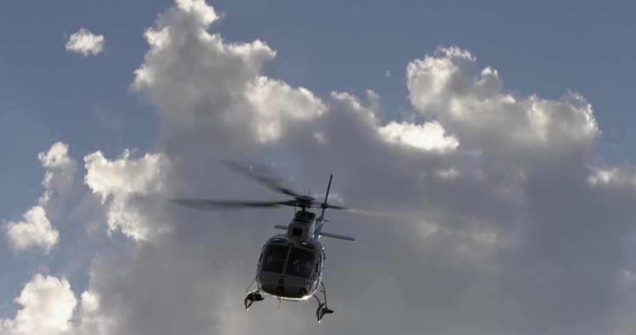 Helicopter flying overhead passes close to the camera