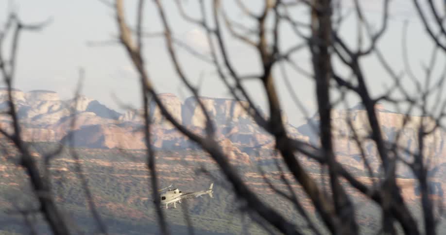 A helicopter flies over a mountain valley