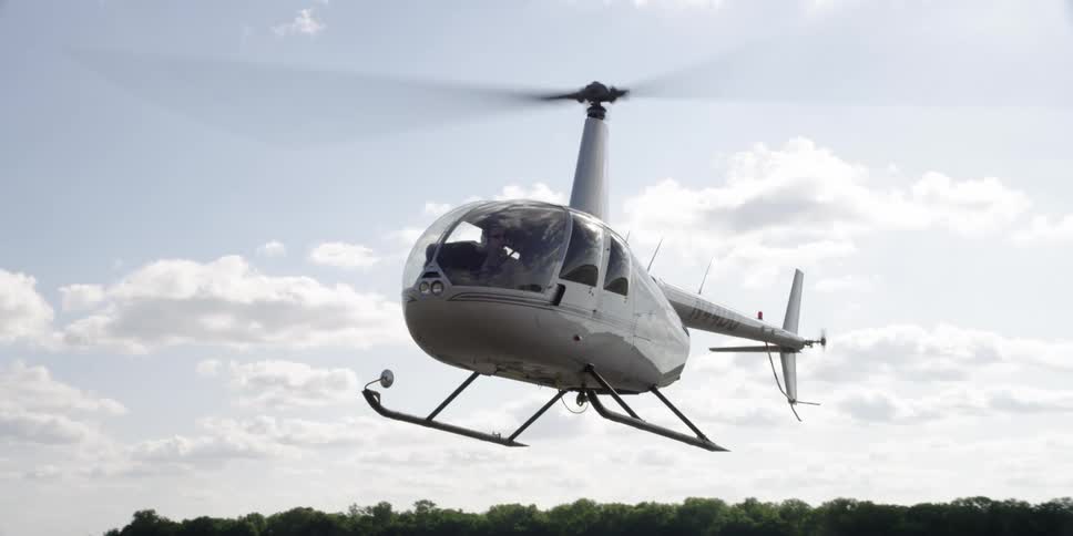 A helicopter flying just above the ground
