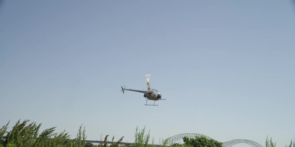 A helicopter is driving in the sky above a rural area