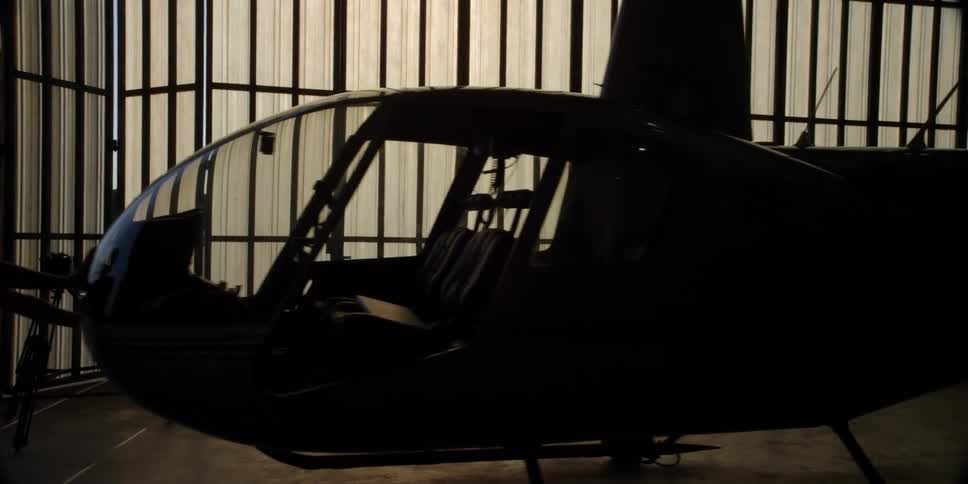 A man pushes a helicopter in a building