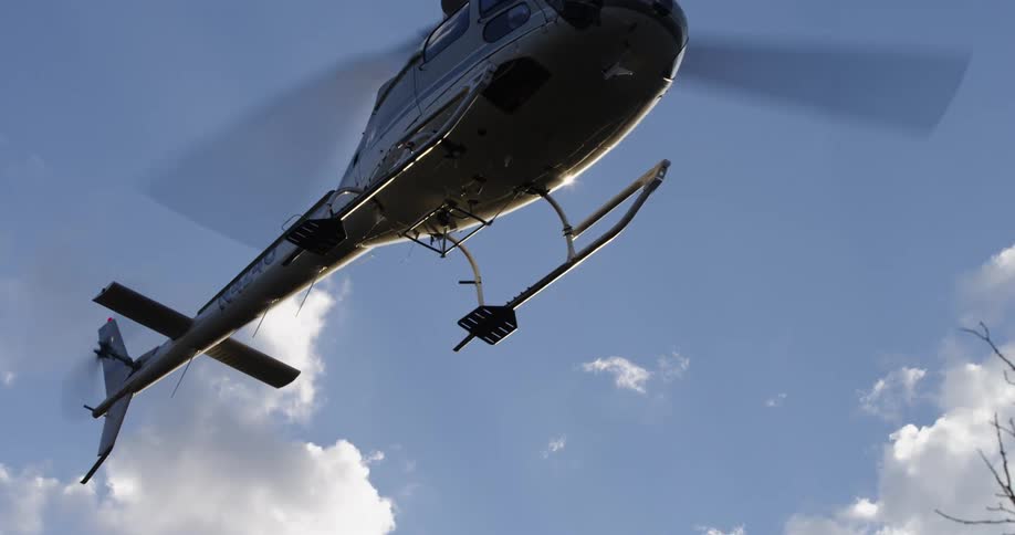 A helicopter is flying above the ground