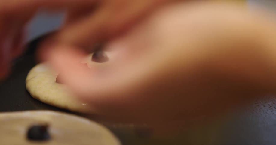 A person prepares blueberry pancakes at home