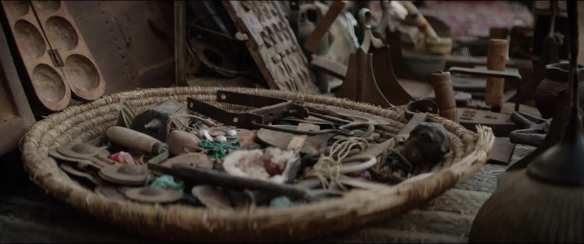A wicker basket filled with assorted items on a table at an outdoor market